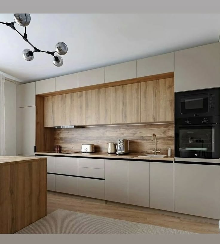 a modern kitchen with wooden cabinets and white walls, an overhead light fixture hangs from the ceiling