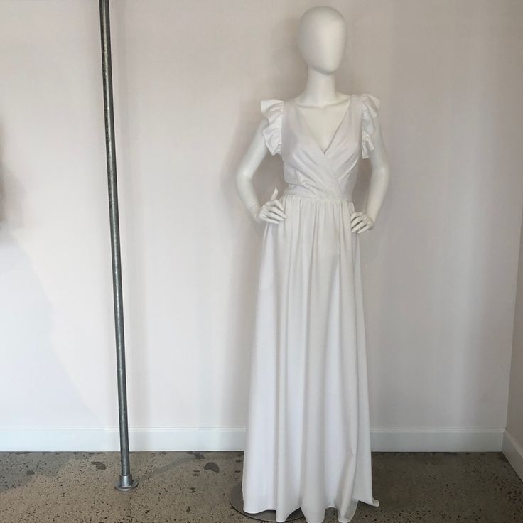 a mannequin is standing next to a white dress