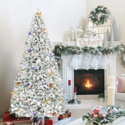 a decorated christmas tree in front of a fireplace