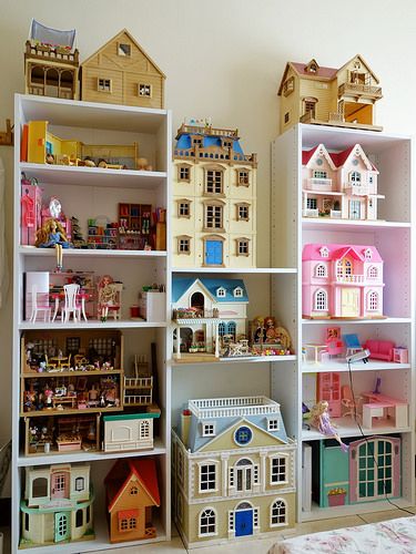 a room filled with lots of different types of toy houses on top of bookshelves