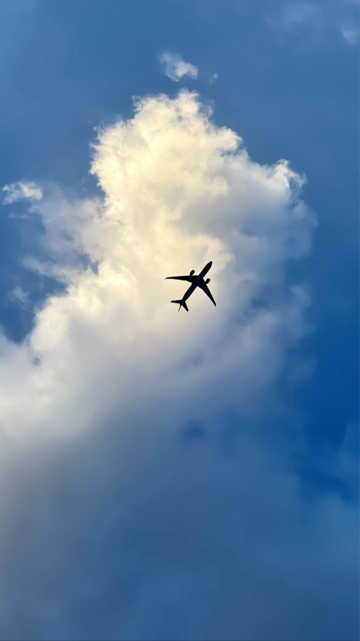 an airplane is flying through the clouds in the blue sky and there is no image to describe