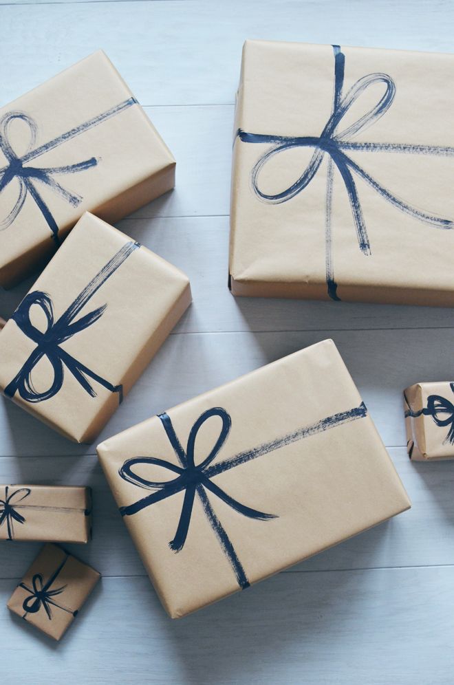 four wrapped presents are sitting on the floor next to each other, tied with blue ribbon