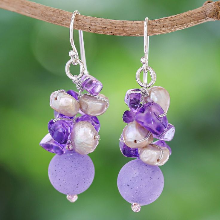 Thailand's Nareerat puts all her expertise into this wonderful creation of multiple gems following a luxurious color scheme. Cultured pearls, amethyst chips and quartz beads come together to form these dangle earrings in a mystic purple tone. The color symbolizes nobility and wisdom, adding a special meaning to the accessory. In addition, the artisan adds sterling silver hooks and silk threads to join every element together. Purple Gemstone Beads Dangle Earrings, Purple Gemstone Bead Dangle Earrings, Purple Dangle Earrings With Gemstone Beads, Handmade Purple Dangle Pearl Earrings, Dangle Gemstone Pearl Earrings For Jewelry Making, Thailand Gifts, Purple Dangle Earrings, Pearl Cluster Earrings, Purple Tone