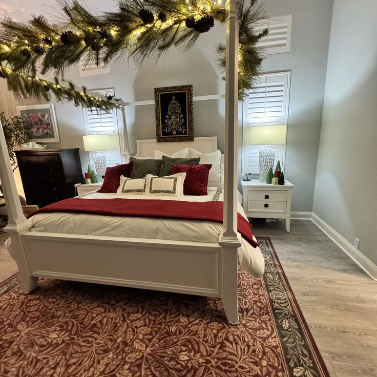 a white bed sitting in a bedroom next to a christmas tree