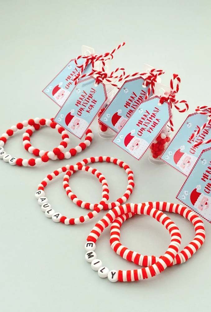 red and white bracelets with name tags on them sitting next to candy canes