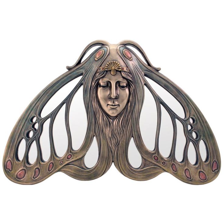 a woman's face is depicted in an intricately designed brooch with wings