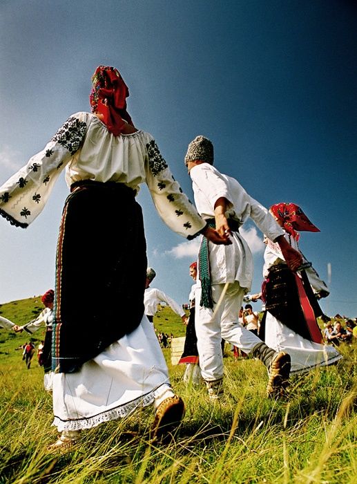 several people in traditional clothing are walking through the grass