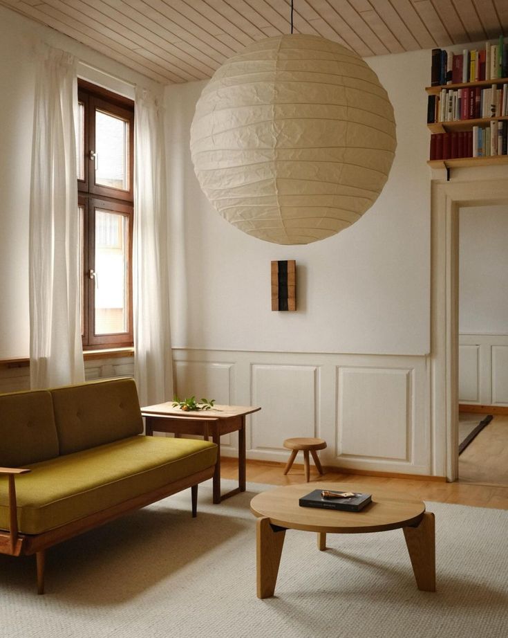 a living room filled with furniture and a large lantern hanging from the ceiling above it