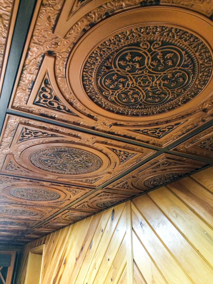 an ornate ceiling with wood paneling and decorative designs on the top part of it