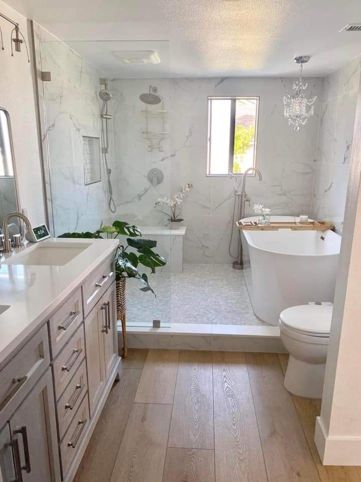 a bathroom with a tub, sink, toilet and shower in the middle of it