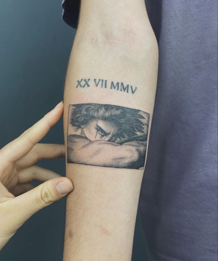 a woman's arm with a black and white photo on it that says vimm xx