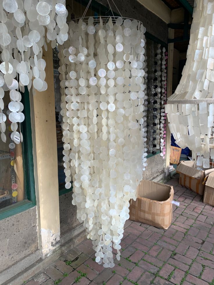 a bunch of white plastic bottles hanging from the side of a building next to a basket