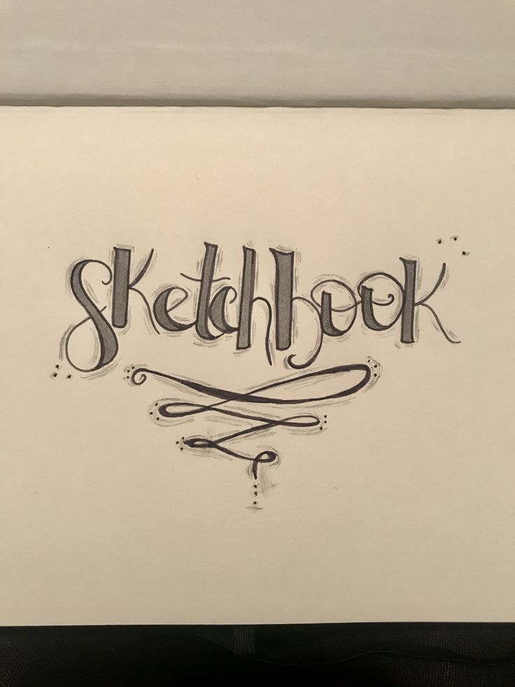 the word sketchbook written in cursive ink