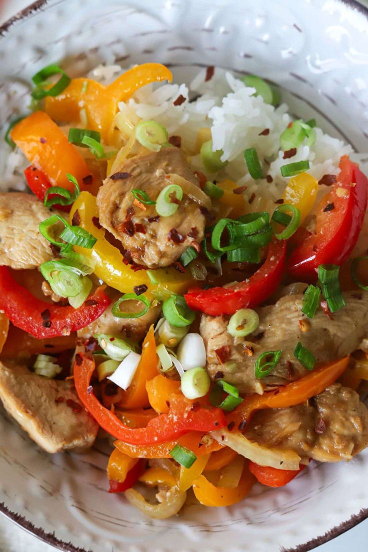 a white bowl filled with rice, meat and veggies on top of it