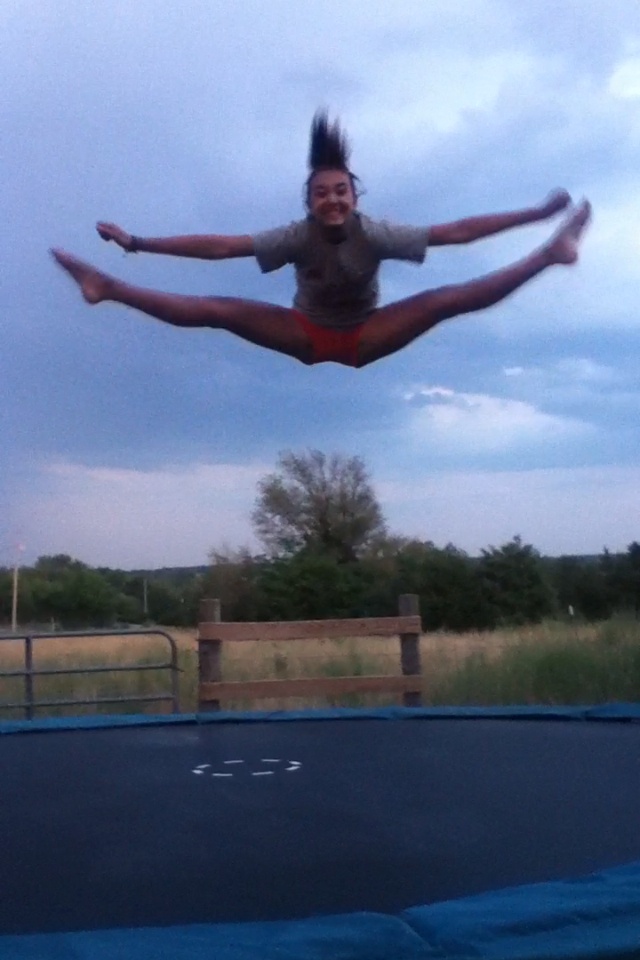 a person jumping on a trampoline in the air with their legs spread out