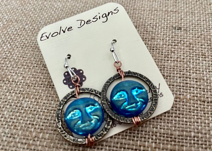 Beautiful recycled blue glass moon face celestial circle drop dangle earrings.  They measure 1.5 long Blue Moon-shaped Sterling Silver Earrings, Symbolic Blue Metal Jewelry, Symbolic Blue Nickel-free Jewelry, Blue Symbolic Nickel-free Jewelry, Blue Moon Shaped Sterling Silver Earrings, Hypoallergenic Blue Circular Jewelry, Blue Moon-shaped Earrings With Moon Charm, Blue Moon Shaped Earrings With Moon Charm, Nickel-free Blue Earrings