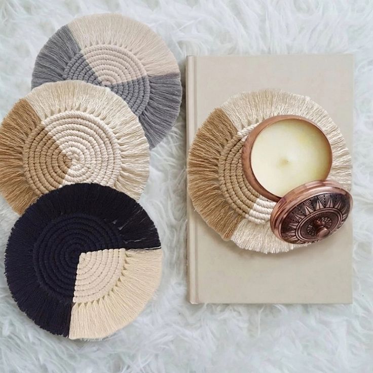 three woven coasters and a candle on top of a white furnishing area