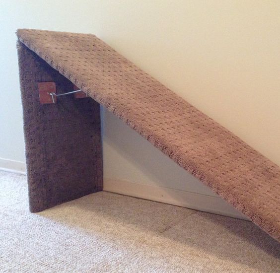 a cat house made out of an old door and some carpet on the floor next to it