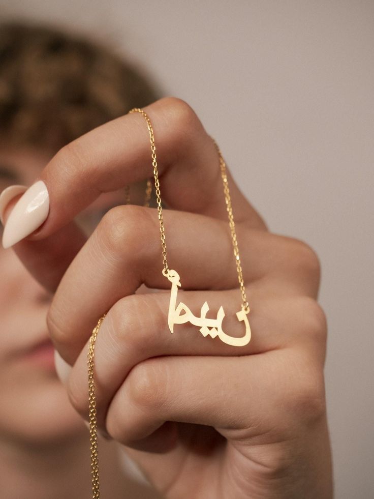 ⚜ Embark on a journey of elegance and individuality with our exquisite Personalized Arabic Name Necklace, crafted with meticulous attention to detail and plated with 14K gold to ensure timeless beauty. Each piece is adorned with stunning Arabic calligraphy, showcasing the artistry of personalized jewelry. It promises to be a cherished adornment that will elevate any ensemble and serve as a symbol of your unique identity for years to come. ⚜ ⚜ Features and Benefits: High-quality 14K gold plating Customizable with Arabic calligraphy Elegant and timeless design Perfect for personal use or as a thoughtful gift Durable and long-lasting craftsmanship ⚜ Size: 14" ≈ 35 cm 16" ≈ 40 cm 18" ≈ 45 cm 20" ≈ 50 cm 22" ≈ 55 cm 24" ≈ 60 cm ⚜ Why Choose This Excellent Product: Expresses individuality and cu Customized White Gold Elegant Name Necklace, Luxury Engraved Name Necklace For Personalized Gift, Luxury Necklace With Intricate Design For Gift, Elegant Hallmarked Name Necklace For Personalized Gift, Elegant Custom 14k Gold Necklace, Intricate 14k Gold Jewelry As Gift, 14k Gold Jewelry With Intricate Design As Gift, 14k Gold Jewelry With Intricate Design For Gift, Luxury White Gold Name Necklace For Wedding