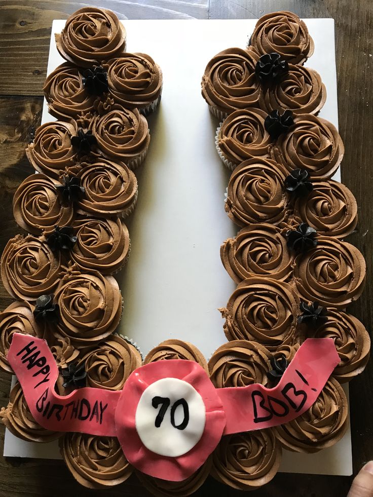 a birthday cake made to look like the number seventy with chocolate frosting and pink ribbon