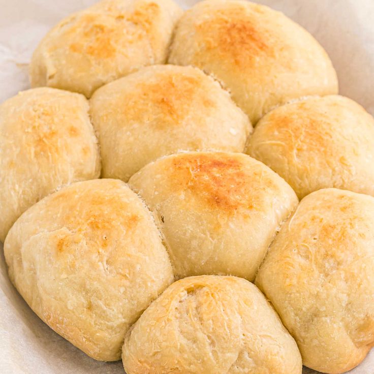 a pile of bread rolls sitting on top of a white paper towel in a bowl