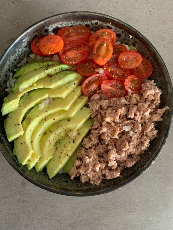 an avocado, meat and tomatoes in a bowl