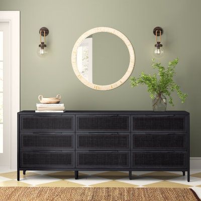 a large black dresser sitting in front of a mirror