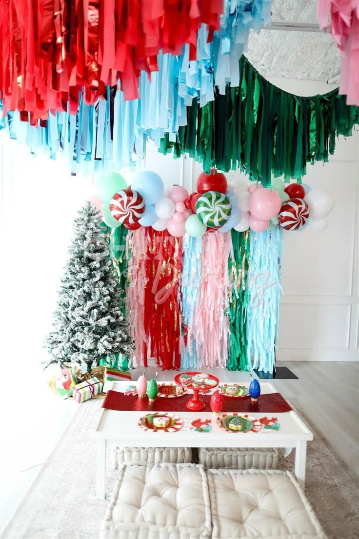 christmas decorations and streamers hang from the ceiling above a table with candy canes on it