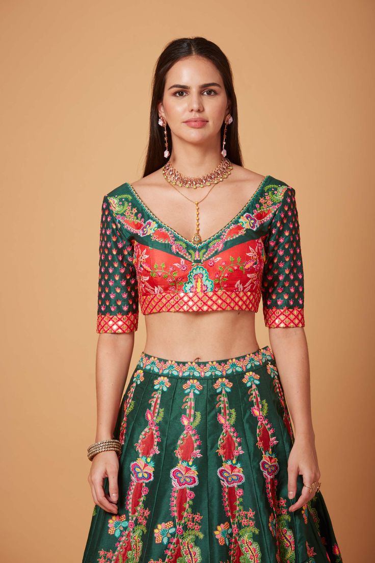 Editor's Note Green Red Embroidered Blouse and SB Signature Lehenga with Embroidered Maroon Net Scallop Dupatta. Fabric: Dupion, Net Color: Green, Red Care: Dry Clean Only Disclaimer: Product Color May Slightly Vary Due To Photographic Lighting Sources Or Your Monitor Setting. About the Designer Siddhartha Bansal, label epitomise its design philosophy touring around " Golden bird" nation to present day India, in the wanderlust for rich Craft and Culture presenting to the world . Vision is to giv V Flower, Blouse Yoke, Lehenga Pattern, Red Lehenga, Embroidered Lehenga, Lehenga Blouse, Flower Motif, Green Blouse, V Cuts