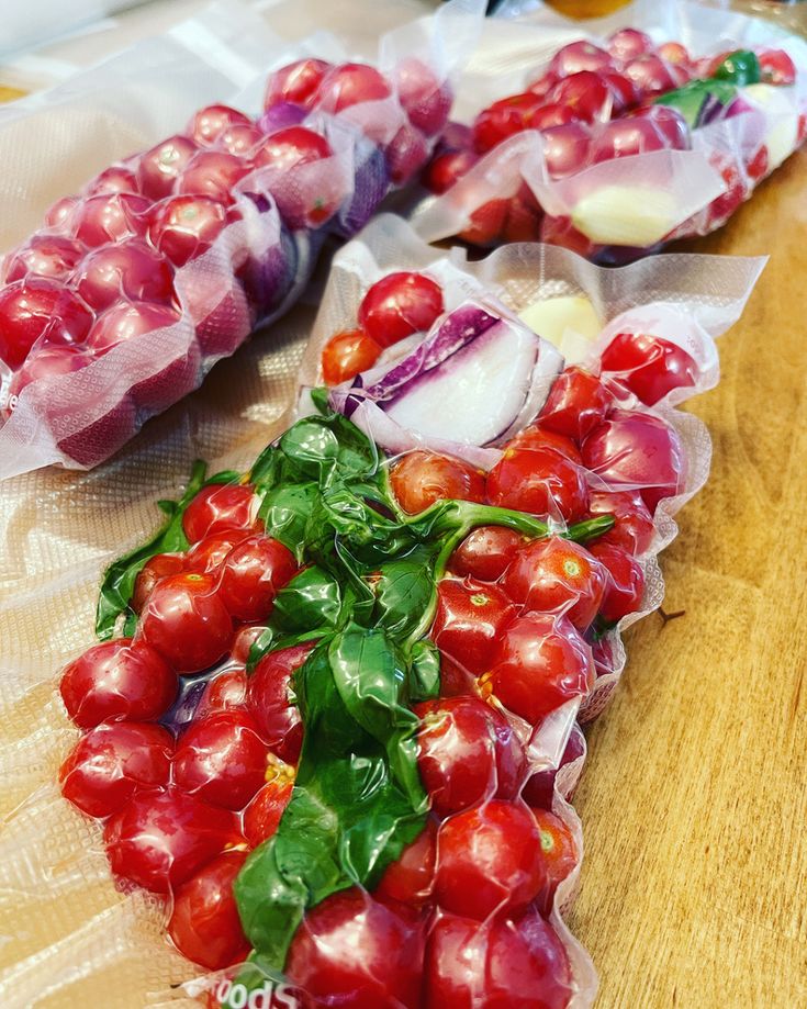 tomatoes, onions and other vegetables are wrapped in cellophane on a cutting board