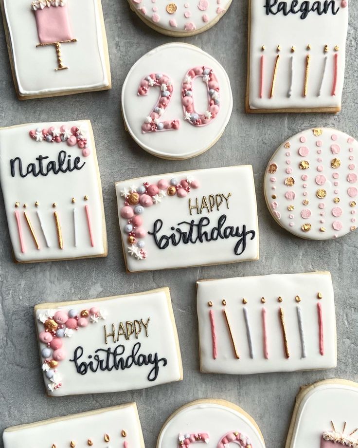 decorated birthday cookies with candles and decorations on a gray table top, including one that says happy birthday