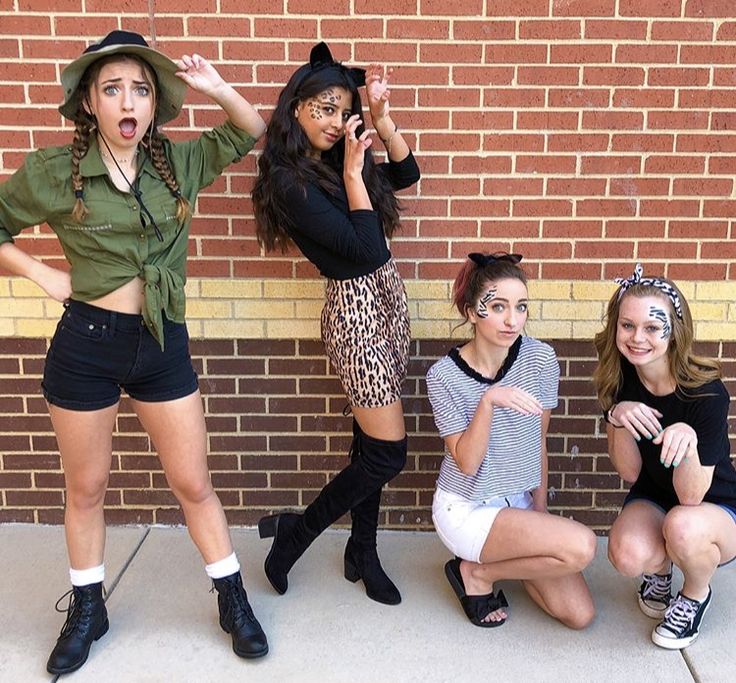 four girls posing in front of a brick wall with their hands on their hipss