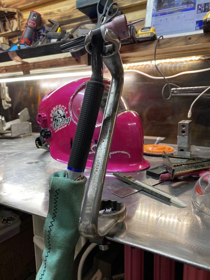 a pair of wrenches sitting on top of a piece of metal in a workshop