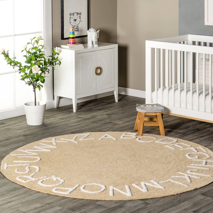 a baby's room with a white crib, dresser and rug that says welcome home