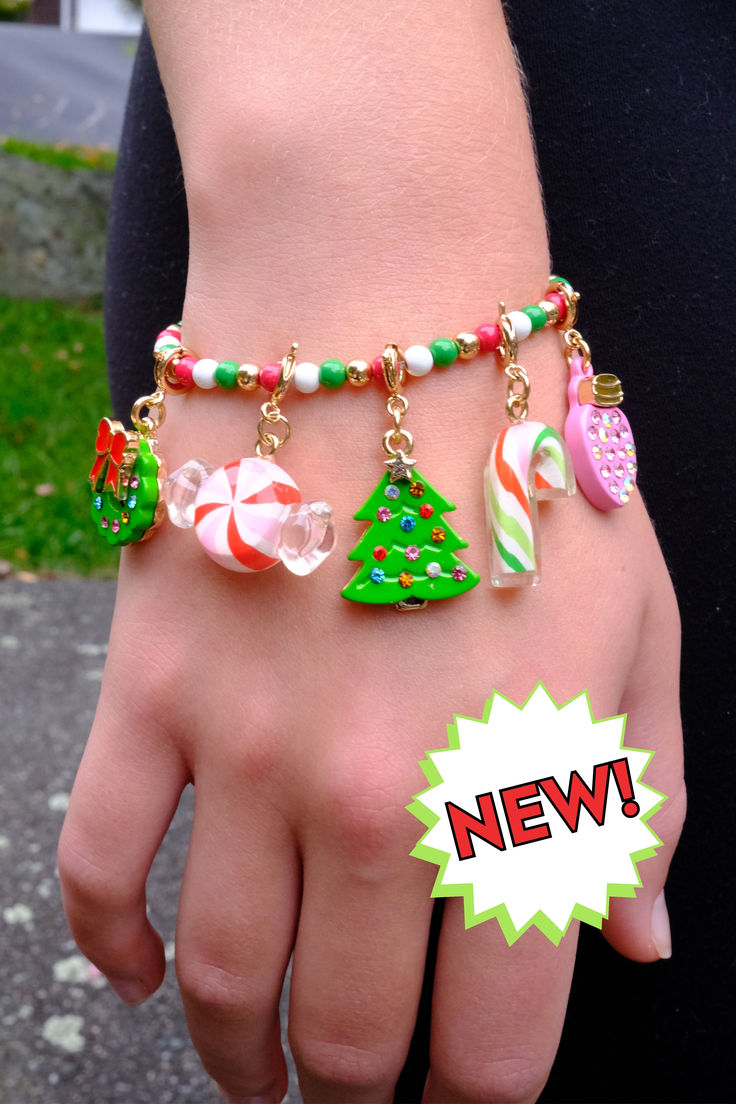 a woman's hand wearing a bracelet with candy canes and christmas decorations on it