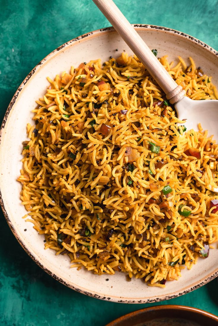 a white bowl filled with yellow rice and vegetables