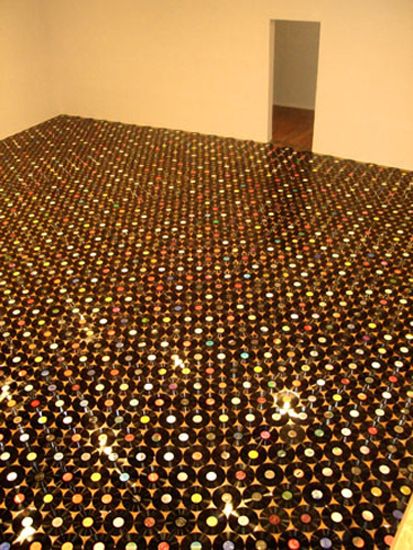 the floor is covered with many different colored circles in an empty room that appears to be made out of various objects