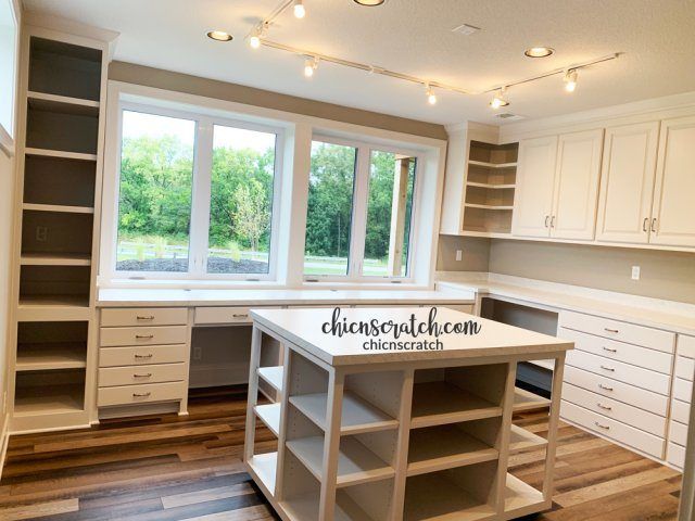 an empty kitchen with lots of cabinets and drawers on the counter top in front of a large window