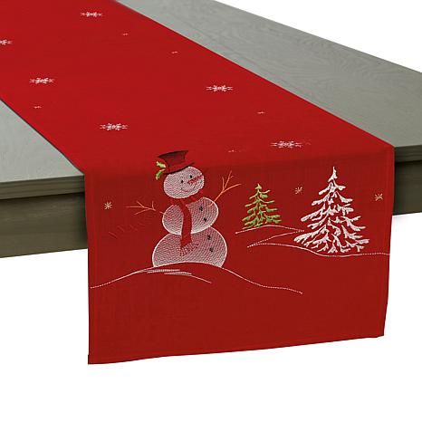 a red table runner with a snowman on it