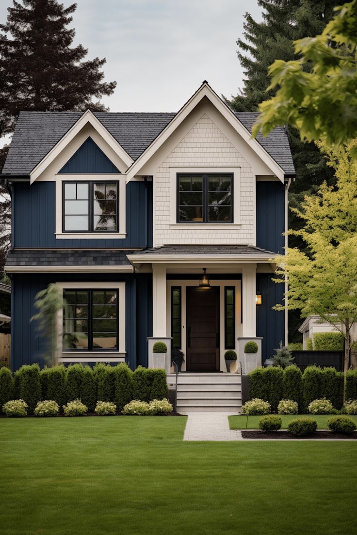 a blue and white house with trees in the front yard