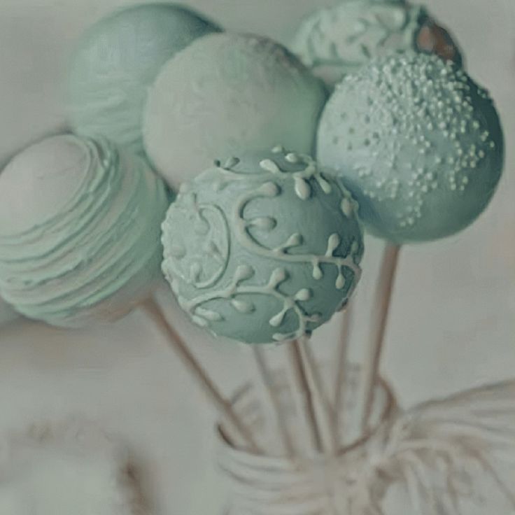 some cake pops are in a glass vase