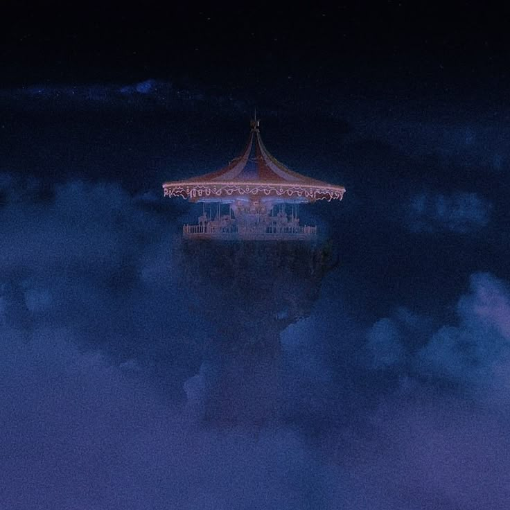 a carousel in the clouds at night