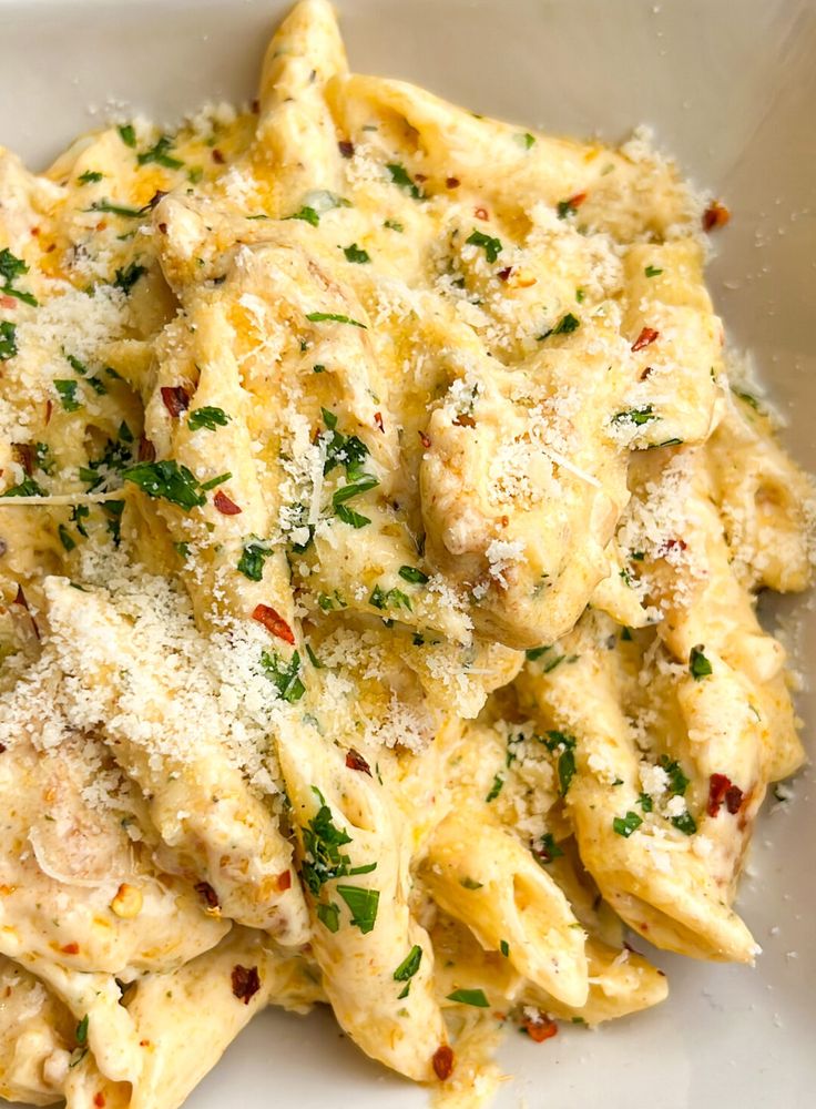 pasta with chicken and parmesan cheese in a white bowl