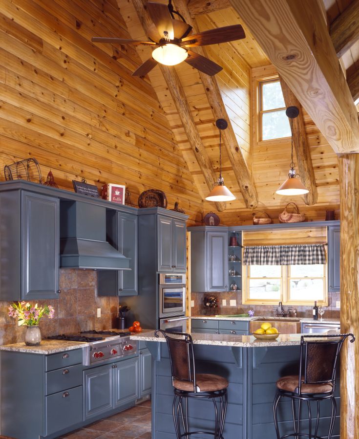 a kitchen with blue cabinets and wooden ceiling