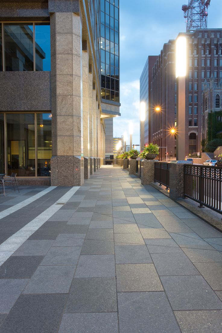 an empty city street at dusk with buildings in the background