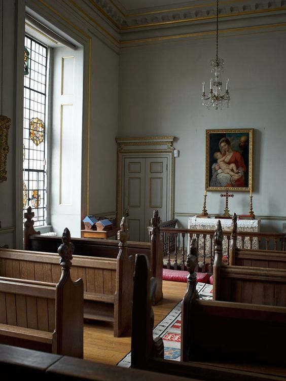 an old church with pews and chandelier in the center, stained glass windows