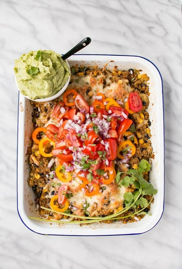 a casserole dish with vegetables and guacamole on the side