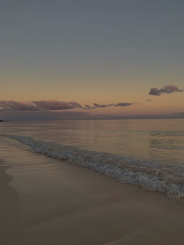 the sun is setting over the water at the beach