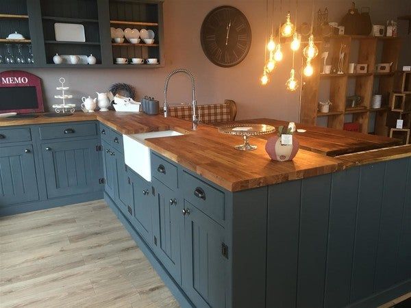 a large kitchen with wooden counter tops and blue cabinets