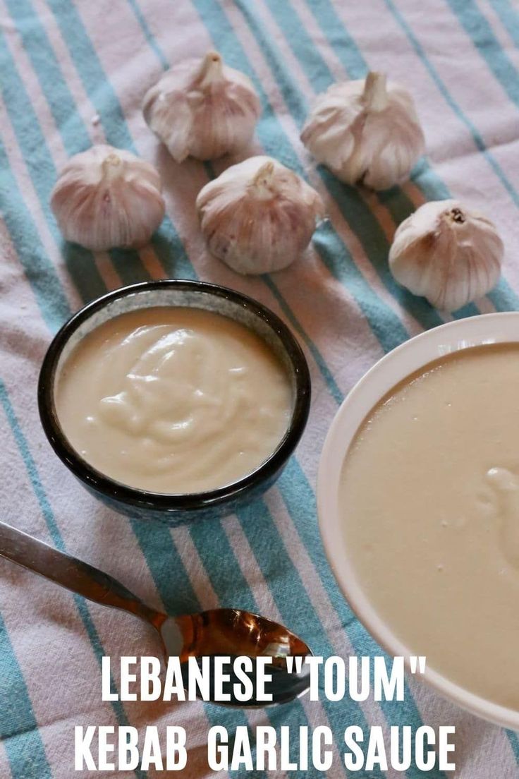 a bowl of soup next to some garlic on a blue and white tablecloth with the words lebanese't town kebab garlic sauce